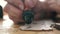 Close-up hand of a craftsman holds a pyrography tool and draws a pattern on a wooden board.  Home Craft