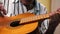 Close-up of the hand of an elderly man playing an old acoustic guitar, a pensioner recalls how to play a musical instrument. Selec