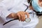 Close up hand female doctor in blue medical mask showing stethoscope for checkup auscultate heartbeat and breath patient.