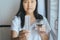 Close up of hand female holding birth control pill and a glass of water