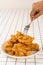 Close Up Hand and Fork on Fried Chickens on white Plate Isolated on table. Look Yummy and Yellow Gold Color