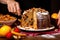 close up of hand garnishing a sliced panettone with nuts