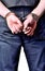 Close-up of hand with handcuffs - arrested, detained man - vertical photo