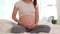 Close up hand Happy Pregnant Woman sitting on bed holding and stroking her big belly at home,Pregnancy of young woman enjoying