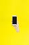 close up hand hold phone on yellow, mock-up smartphone black color blank screen