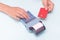 Close-up of a hand holding a bank card and a hand holding a check, receipt on a cash register on a blue background