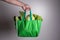 close up hand holding green grocery bag of mixed the organic green vegetables , healthy organic green food shopping and diet heal