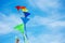 Close-up of a hand holding kites group over blue sky