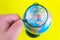 Close-up of a hand holding a magnifying glass to look at the globe in the library selective focus Ukraine