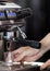 Close up hand holding of making coffee with machine in cafe. Professional modern espresso coffee machine pours hot drink into the