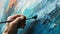 close up of hand holding painbrush drawing painting on canvas with blue color