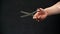 Close-up of a hand holding a pair of hairdressing scissors, on a black background