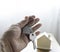 Close-up of hand holding silver keys house with house shaped keychain and home mockup on wooden table background.