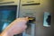 Close up of hand inserting card to atm machine