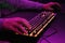 Close-up of a hand on a keyboard in neon color. Selective focus