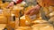 Close up hand of male consumer taking cheese from fridge with dairy at supermarket. Man selecting milk products in