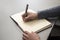 Close up of a hand of a man ready to write on a notebook