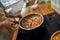 Close up of hand of man tossing shrimp with garlic and onion in the frying pan. Cook preparing dish with seafood