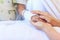 Close up hand of parent holding hand of child in hospital.