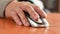 Close-up of the hand of a pensioner holding a computer mouse. Training a psionary to work on a computer. An active elderly man spe