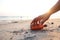 Close up hand pick glass Bottle on the beach