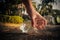 Close up Hand picking up clear plastic bottle water drink with a green cap on the road in the park at blurred background