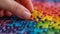 Close-up of a hand placing the final piece into a vibrant jigsaw puzzle