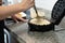 Close-up of a hand placing waffle batter in the waffle iron