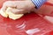 Close Up Of Hand Polishing Car Hood Using Cloth