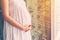 Close up hand pregnant woman holding tummy with vintage toned