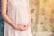 Close up hand pregnant woman holding tummy with vintage toned