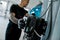 Close up of hand of professional male mechanic operating hydraulic lift, pushing button up at auto repair shop