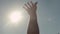 Close-up of hand reaching for sun. Stock. Man reaches out to sky in pleasure from warm rays of bright sun. Swimming in