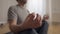 Close-up hand of relaxed sportsman sitting in lotus pose meditating. Blurred unrecognizable middle aged Caucasian man