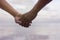 Close up hand of senior couple holding hand together near seaside at the beach,filtered image,light effect added,selective focus