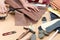 Close up hand of shoemaker cutting a piece of brown leather