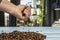 Close-up of a hand stirring a bunch of roasted coffee beans