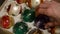 Close up of hand taking out shiny aged Christmas speheres from box. Detail of Man takes out vintage brightly XMas balls for decor