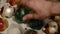 Close up of hand taking out shiny aged Christmas speheres from box. Detail of Man takes out vintage brightly XMas balls for decor