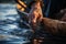 Close-up of hand touching the water, person seated in a wooden boat