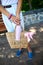 Close up of hand of trendy woman in with straw bag with pink medical mask in handbag outdoors in the city,