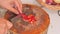 Close-up hand using knife sliced ripe chili on the cutting board in the kitchen