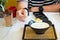 Close up hand using spoon holding ginkgo with coconut milk on black bowl in cafe