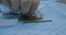 Close-up. The hand of a veterinary surgeon takes a screw from the table in the operating room to fix the plate on the