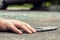 Close-up of hand of a victim and smartphone after dangerous incident on the road