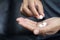 Close up hand woman holding taking multiple pills.