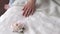 Close-up of a hand of a young girl on the bed, lying next to a peony flower.