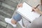 Close up hand young woman are sitting on a marble chair. using pen writing Record Lecture note pad into the book