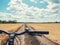 Close-up of handlebar mountain bike on the path of the yellow field in the countryside.