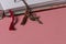 Close-up of handmade notebook dividers with braided thread with copper dancer on the tip, on a pink table